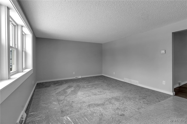 carpeted empty room featuring visible vents and baseboards