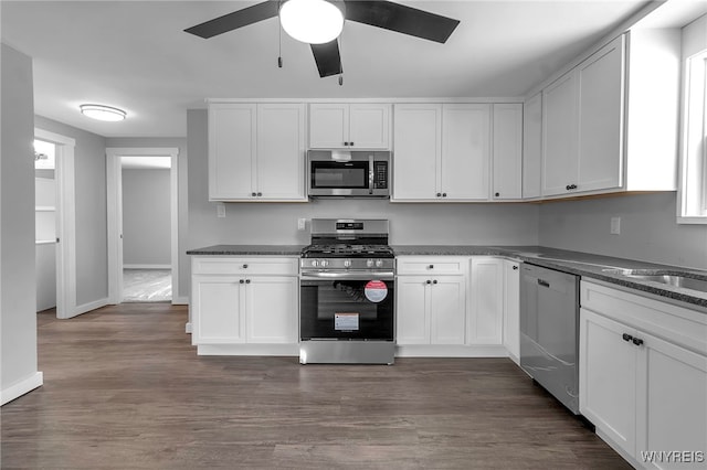 kitchen featuring stainless steel appliances, white cabinetry, ceiling fan, and dark wood-style floors