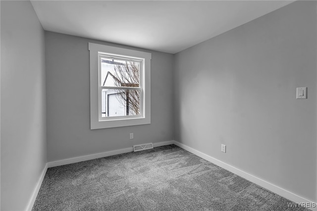 spare room featuring baseboards, visible vents, and carpet flooring