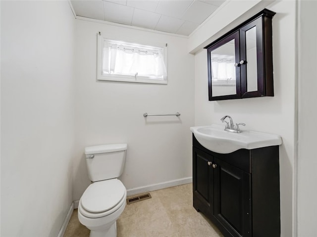 bathroom featuring toilet, vanity, visible vents, and baseboards