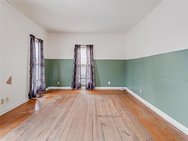 unfurnished room with wood-type flooring and baseboards