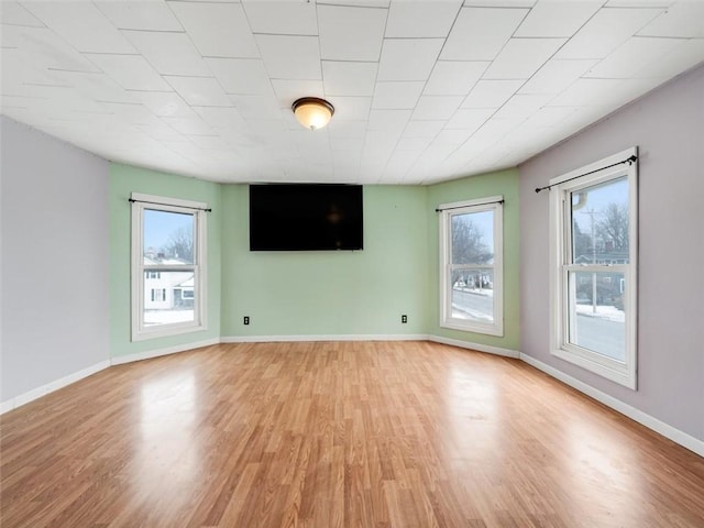 unfurnished living room with light wood-type flooring and baseboards