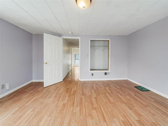 unfurnished bedroom with light wood-type flooring, visible vents, and baseboards