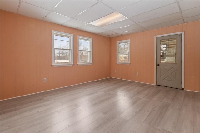 empty room with a paneled ceiling and wood finished floors