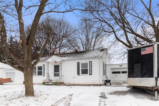 view of front of property with a sunroom, a chimney, and an attached garage