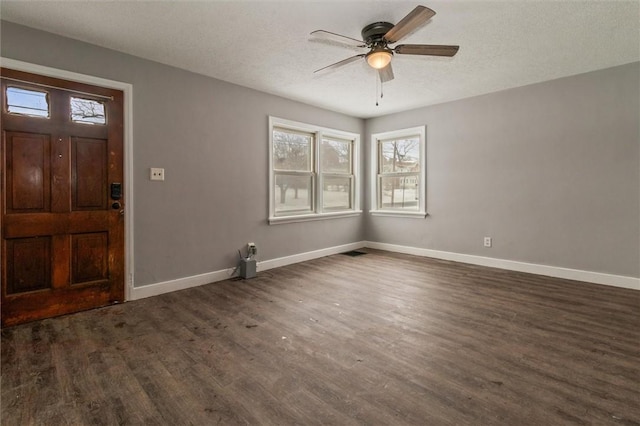 entrance foyer featuring dark wood-style floors, a textured ceiling, a ceiling fan, and baseboards