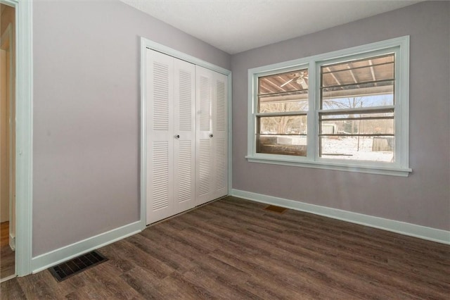 unfurnished bedroom with a closet, visible vents, and baseboards