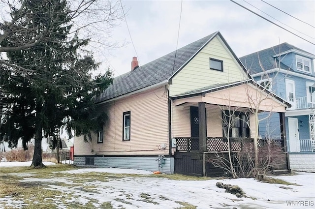 view of front of house with a chimney and a porch