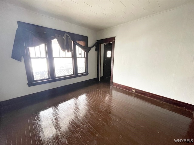 unfurnished room featuring hardwood / wood-style floors and baseboards