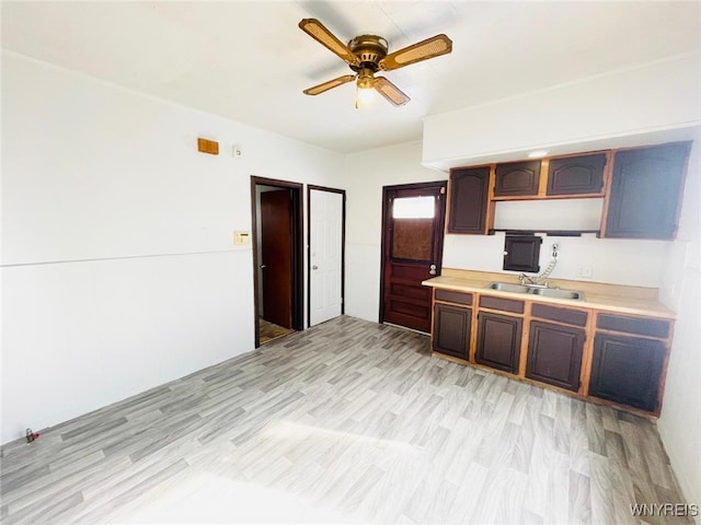 kitchen with ceiling fan, light countertops, light wood-type flooring, and a sink