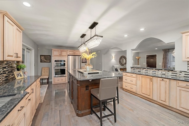 kitchen with light wood finished floors, a center island, and light brown cabinetry