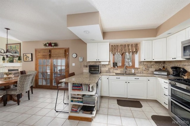 kitchen featuring light stone countertops, white cabinetry, stainless steel appliances, and a sink