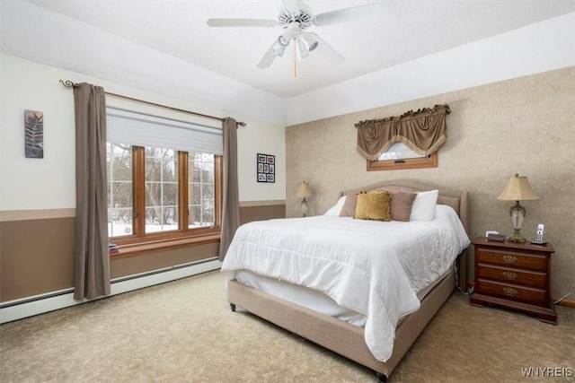 carpeted bedroom with a baseboard radiator and a ceiling fan