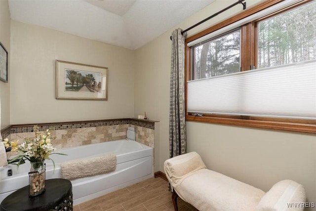 full bath with wood tiled floor and a bath