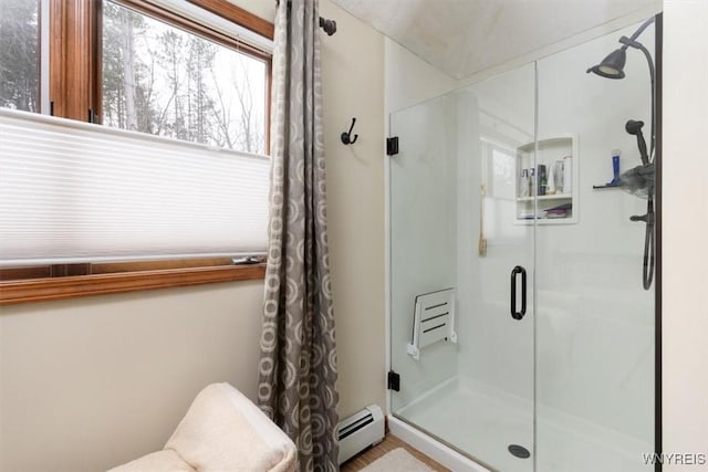 bathroom with a stall shower and baseboard heating