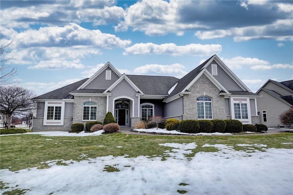 view of front facade featuring stone siding and a yard