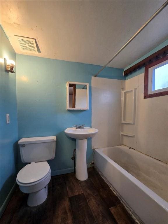 full bath with shower / bathtub combination, visible vents, toilet, wood finished floors, and baseboards