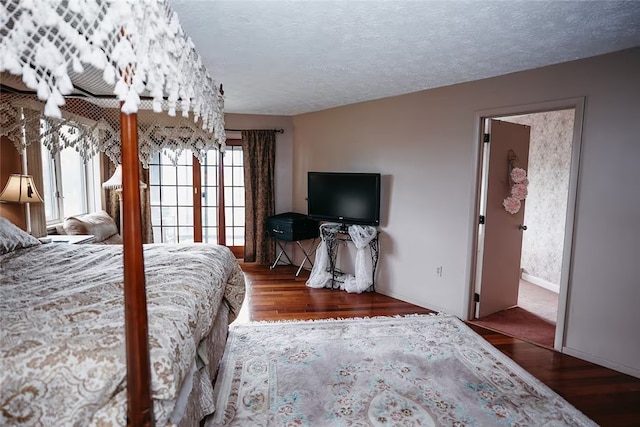 bedroom featuring a textured ceiling, wood finished floors, and baseboards