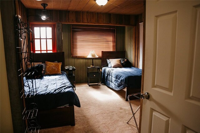 bedroom featuring carpet, wood ceiling, and wooden walls