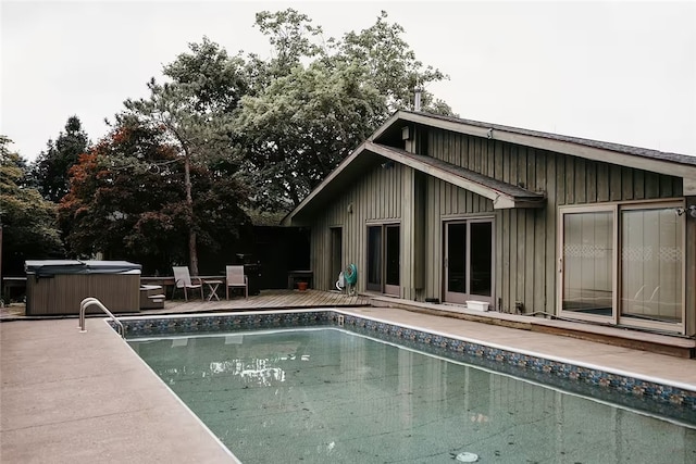 outdoor pool featuring a deck and a hot tub