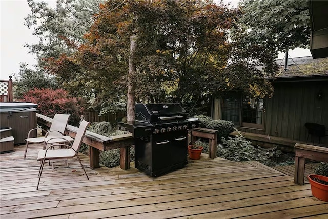 wooden deck featuring a hot tub and fence