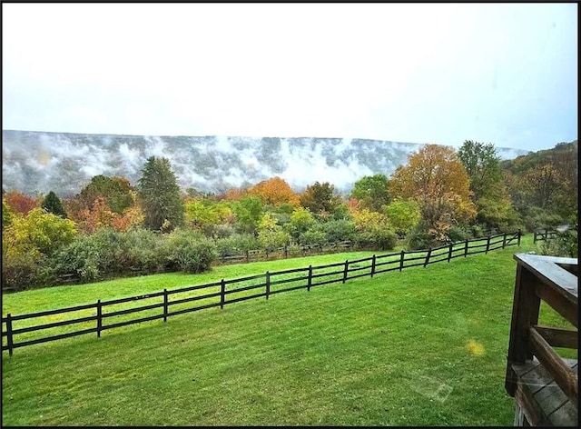 view of yard featuring fence and a rural view