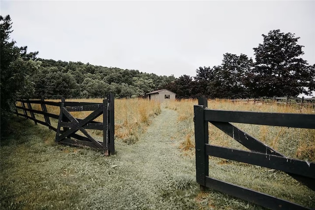 view of gate featuring a rural view and fence