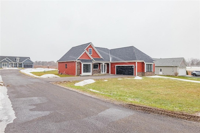 view of front of house featuring a garage, brick siding, driveway, and a front lawn