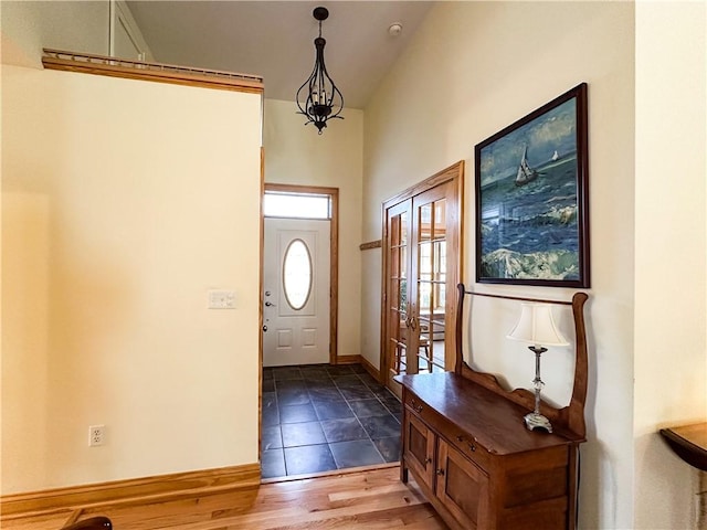 entryway with baseboards, vaulted ceiling, and wood finished floors