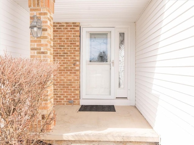 view of exterior entry with brick siding