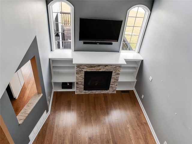 unfurnished living room featuring a fireplace, baseboards, and hardwood / wood-style flooring