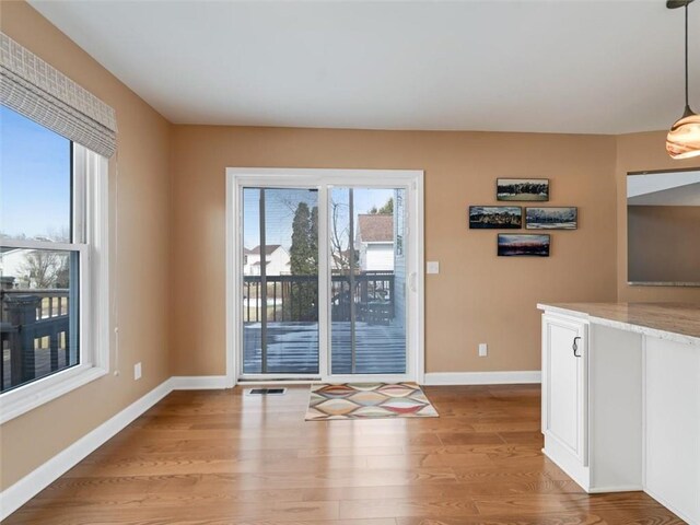 interior space featuring light wood-type flooring, baseboards, and visible vents