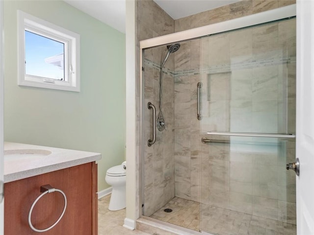 full bath featuring toilet, a stall shower, and vanity