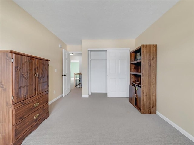 carpeted bedroom featuring baseboards and a closet