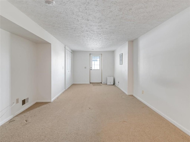 unfurnished room featuring baseboards and a textured ceiling