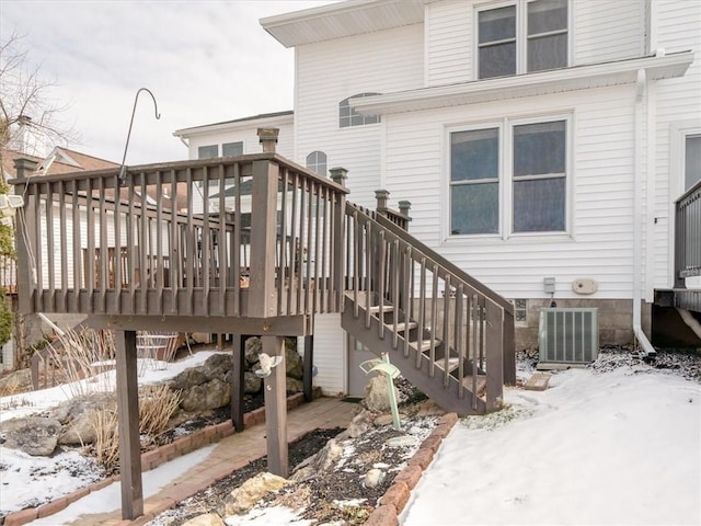 snow covered deck featuring cooling unit and stairs