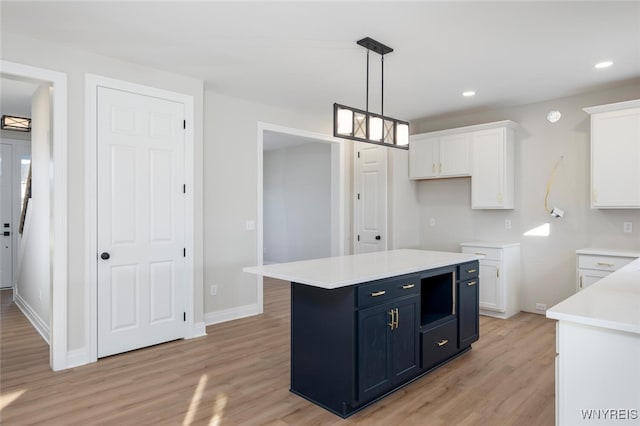 kitchen featuring recessed lighting, light countertops, hanging light fixtures, white cabinetry, and light wood-type flooring