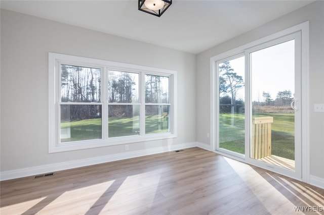 unfurnished room with visible vents, baseboards, and wood finished floors