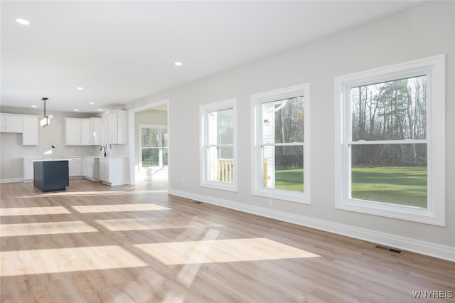 unfurnished living room with plenty of natural light, visible vents, and recessed lighting