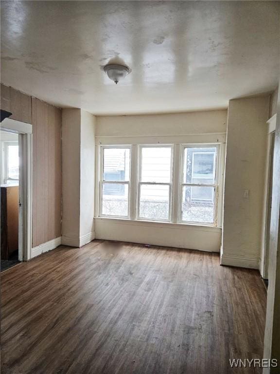 unfurnished room featuring baseboards and wood finished floors