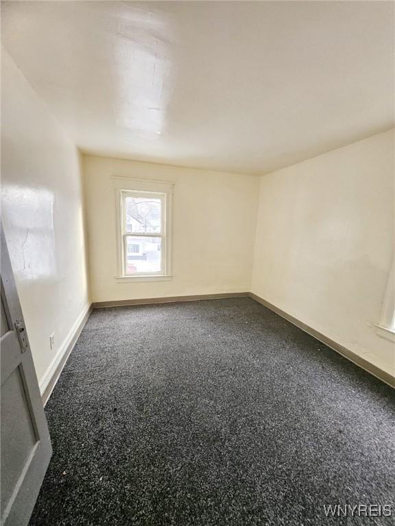 unfurnished room with baseboards