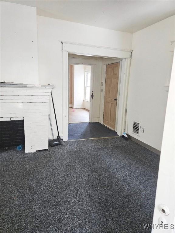 unfurnished living room with visible vents and baseboards