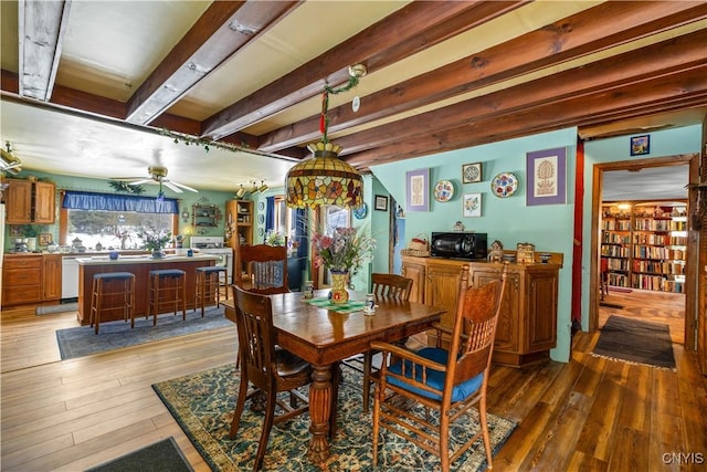 dining area featuring wood finished floors, beam ceiling, and a ceiling fan