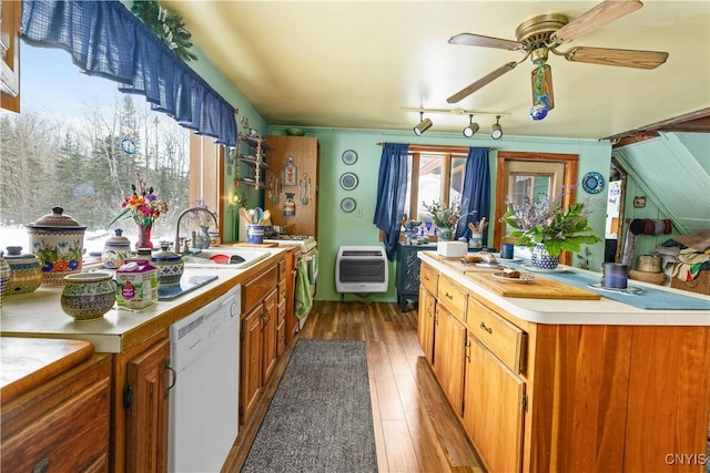 kitchen with white appliances, wood finished floors, heating unit, light countertops, and a sink