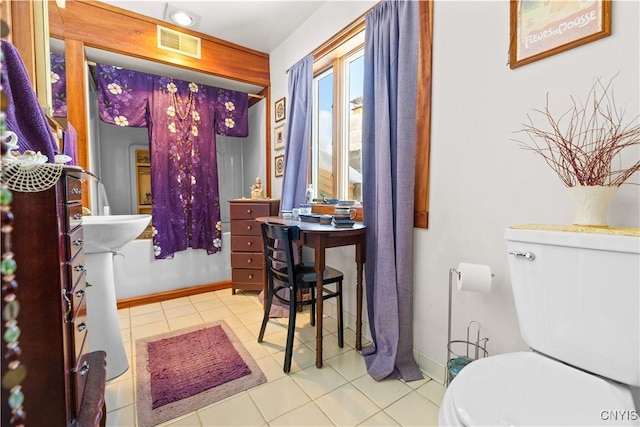 bathroom featuring toilet, baseboards, visible vents, and tile patterned floors