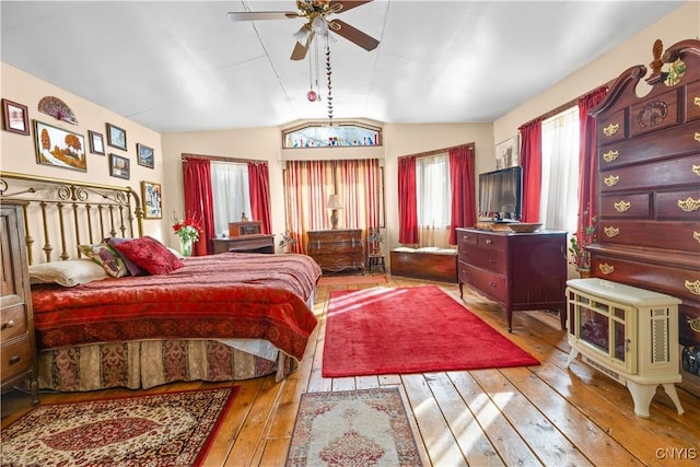 bedroom with vaulted ceiling and hardwood / wood-style flooring