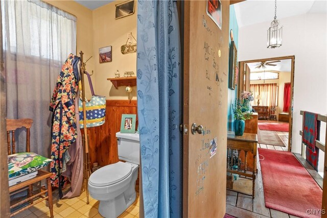 225 Amberg Rd, Ohio, NY 13324 - bathroom featuring wainscoting, toilet, ceiling fan, wooden walls, and tile patterned floors