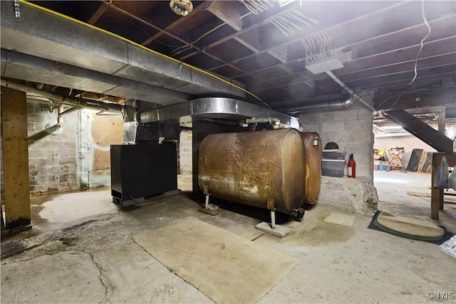 unfinished basement featuring heating unit and heating fuel