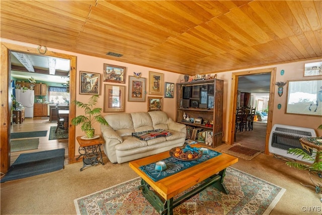 carpeted living area with ornamental molding, wooden ceiling, and heating unit