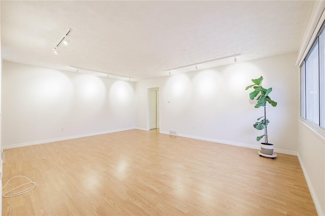 spare room featuring light wood-style floors and baseboards